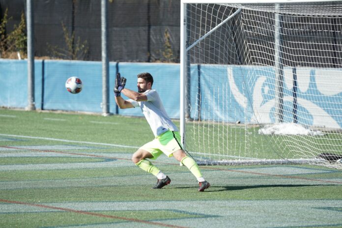 Goalkeeper preparing to make a save during training on a football field