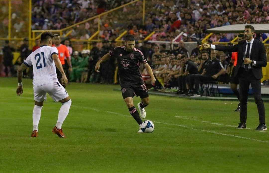 David Dóniga Lara coaching on the sidelines during El Salvador’s match against Inter Miami, with Jordi Alba controlling the ball.