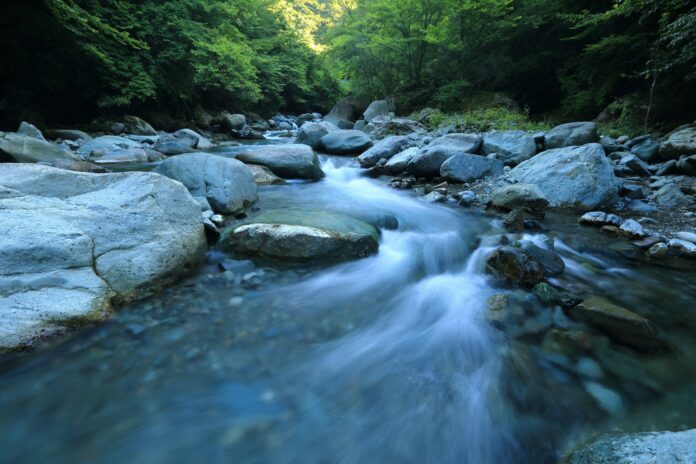 A tranquil mountain river flowing through rocks and forest, symbolizing mental clarity and flow state