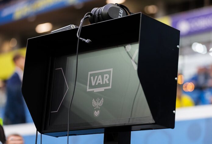 VAR monitor on the sidelines during a football match in Russia, used for video assistant referee decisions.