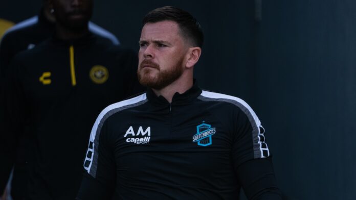 Alan McCann walks out of the tunnel in Switchbacks training gear, focused and composed before a match.