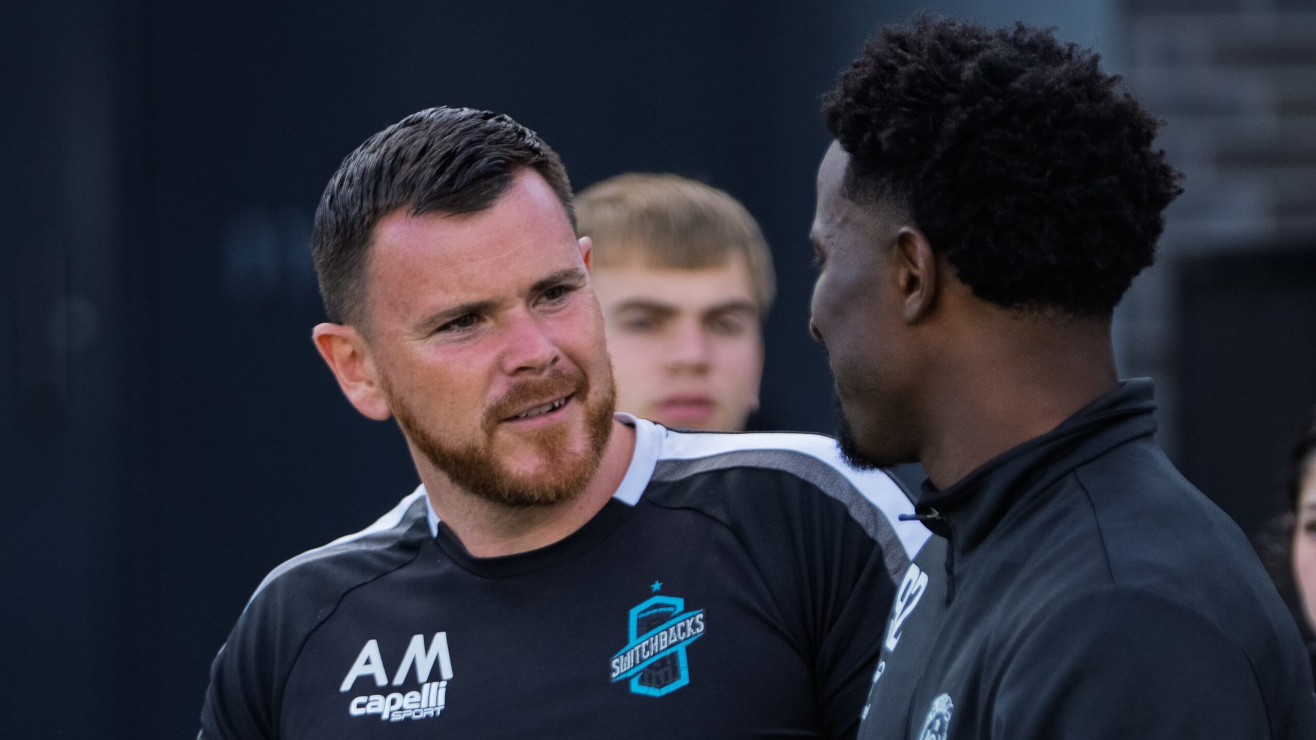 Alan McCann talks with a player during a training session, reflecting his hands-on leadership style at Colorado Switchbacks.
