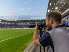Hannes Anger photographing a football match from the sidelines at FC Carl Zeiss Jena’s stadium.