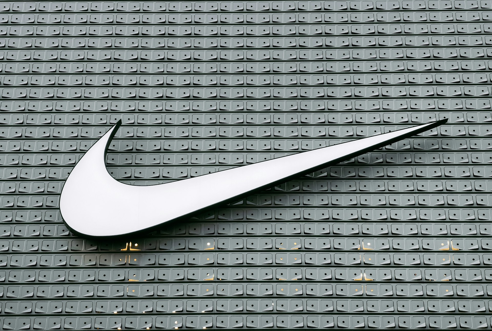 The Nike swoosh logo on a patterned wall, symbolising one of the most iconic sports marketing brands in the world.