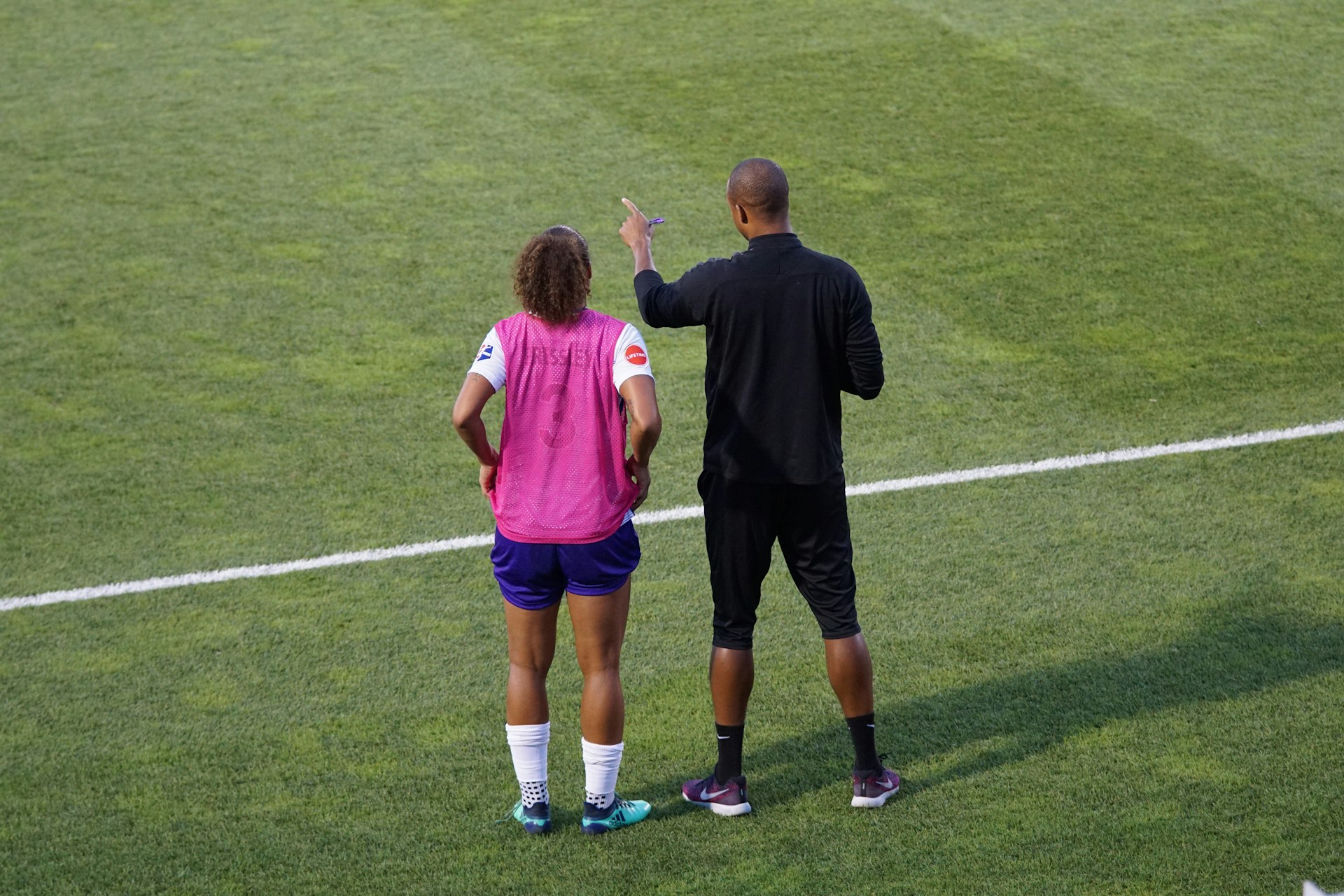 Coach giving tactical or emotional advice to a football player on the sideline during a match, symbolising player support.