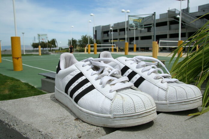 Adidas Superstar Adidas Superstar sneakers placed outdoors, symbolizing the timeless connection between sport, fashion, and culture.