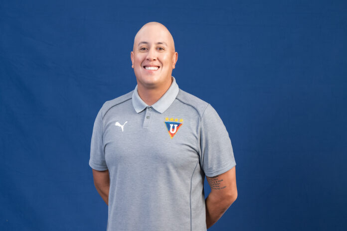 Diego Vilela Alcalá standing confidently in front of stadium seating, reflecting his work in player development and modern football methodology.