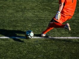 Torhüter Im Offensivspiel Ausbilden Goalkeeper in motion passing the ball during build-up play, highlighting modern offensive responsibilities in football.