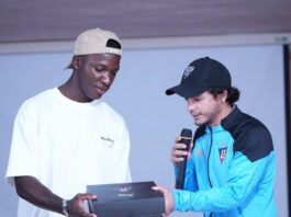 Marco Durán Montenegro presenting a gift to a young player during a club event focused on development and performance culture.