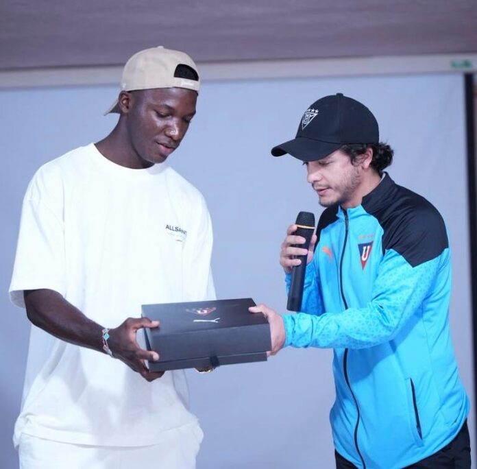 Marco Durán Montenegro presenting a gift to a young player during a club event focused on development and performance culture.