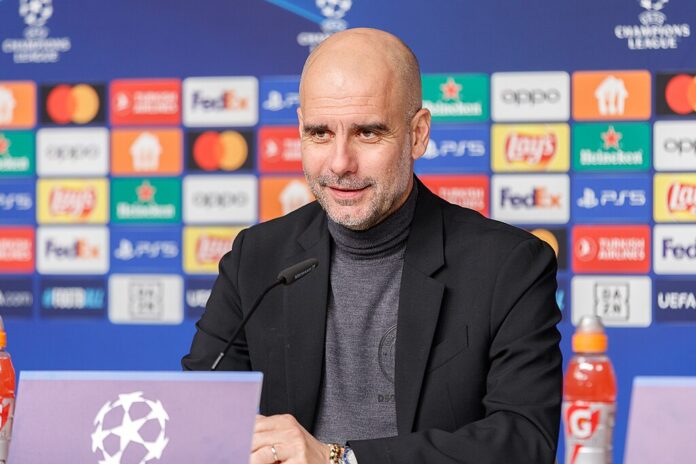 Pep Guardiola speaking at a Champions League press conference, reflecting Spain’s influence on global football coaching.