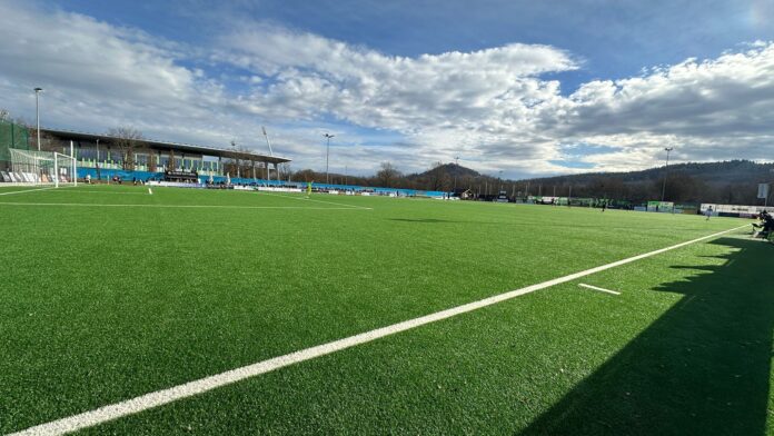Football pitch highlighting space and positioning during a youth match under clear skies.