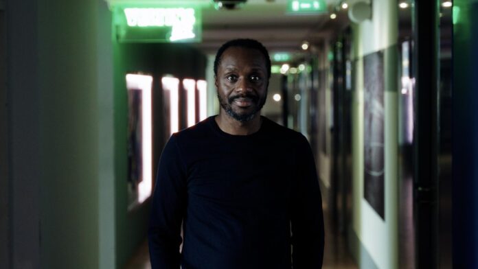 BenManga Ben Manga standing in a stadium hallway, reflecting his role as one of European football’s leading scouting and talent directors.