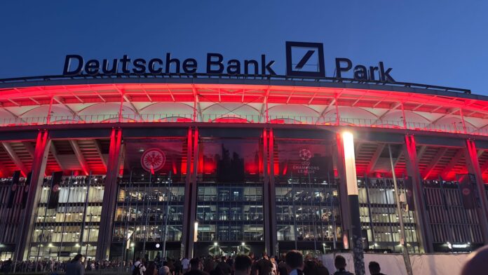 Deutsche Park Deutsche Bank Park stadium lit in red at night showcasing prominent naming rights branding above the main entrance.