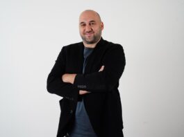 Emir Güney stands with arms crossed, reflecting leadership and expertise in sports education and football governance.