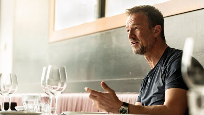 Fredi Bobic speaking during an interview at a restaurant, reflecting on his football and executive career.