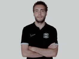 Who is Gianni Piccatti? Gianni Piccatti standing with folded arms in a black Como Women polo during his profile interview for The Football Week.