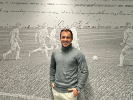 Who is Kevin Cauet? Kevin Cauet stands in front of a football mural, reflecting his global career in coaching, scouting and player development.