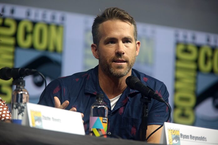 Ryan Reynolds speaking at a Comic-Con panel, known for co-owning Wrexham AFC.