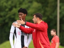 The Art of Set Pieces in Modern Football Coach giving tactical instructions to a young player during a training session for LASK, emphasizing positioning and movement.