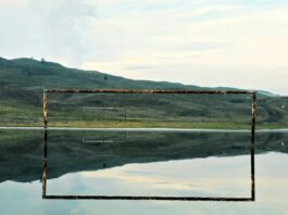 Be Like Water: The Modern Football Manifesto Calm reflective water surface mirroring distant hills, symbolising fluidity and adaptability in the modern game.