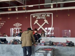 Football, Coal and the Identity of Mining Cities West Ham stadium store with supporters browsing merchandise, highlighting the club’s working-class roots and industrial identity.