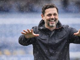 Erol Bulut gestures from the touchline during a match, reflecting his calm leadership and tactical focus as a head coach.