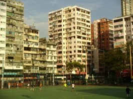 Football pitch surrounded by city buildings, symbolising the social and economic impact of football on urban life.