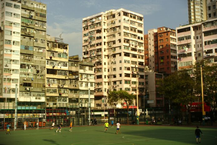 Football pitch surrounded by city buildings, symbolising the social and economic impact of football on urban life.