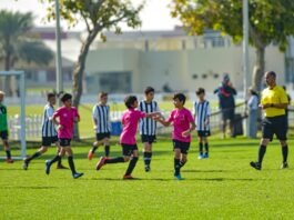 Young football players celebrating together during a grassroots match, reflecting confidence, teamwork, and emotional development on the pitch.