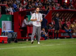 Alex Dorado coaching from the touchline during a competitive match in Cambodia