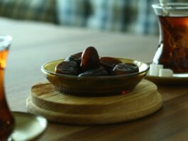Dates and Turkish tea on a wooden table symbolising Ramadan fasting and matchday nutrition in football.