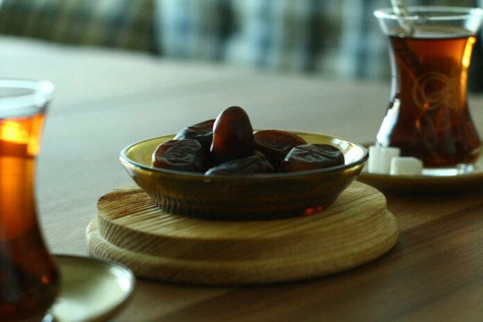 Dates and Turkish tea on a wooden table symbolising Ramadan fasting and matchday nutrition in football.