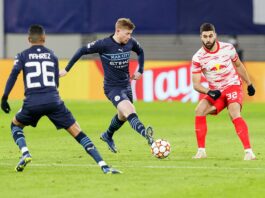 Kevin De Bruyne plays a forward pass for Manchester City under pressure in a Champions League match