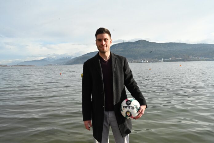 Marc Lamberger first team goalkeeper coach at SK Austria Klagenfurt holding a football by the lake